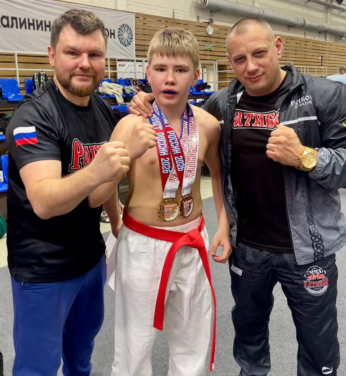 Спортсмен с медалями и тренерами